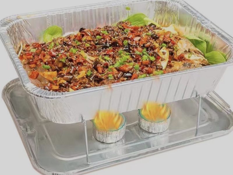 Aluminum steam table pan with catering food on a serving rack