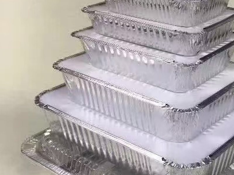 Stacked rectangular aluminum takeout containers with board lids